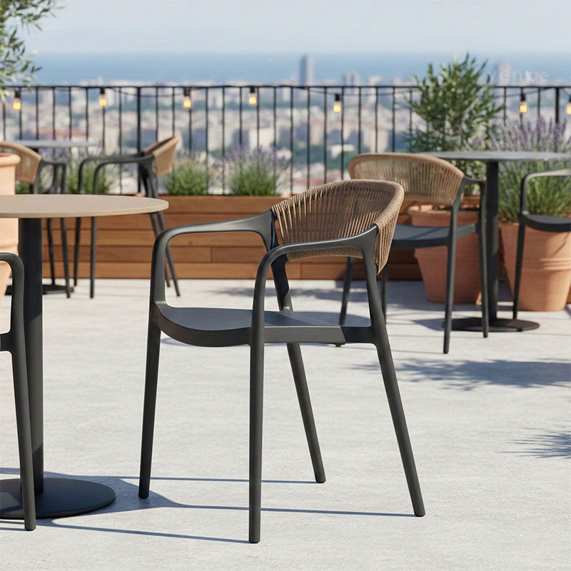Модерна лоунџ фотелја Stackable Armchair Vedane во длабока мат црна боја со ергономски потпирач во природен натур PE ратан декор и стакабилна структура што штеди простор